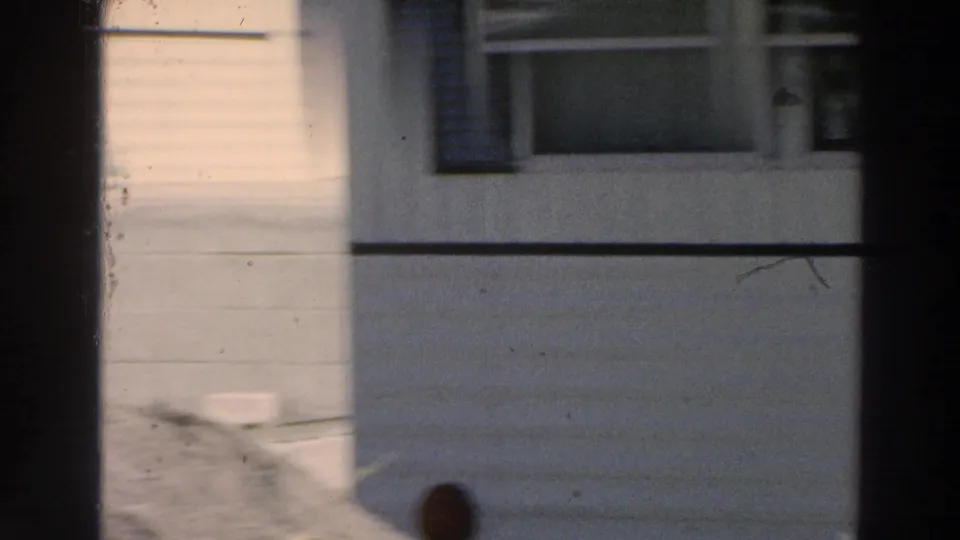 A residential wall and window in Puerto Rico, filmed in 1966 with strong shadow and soft 8mm exposure.