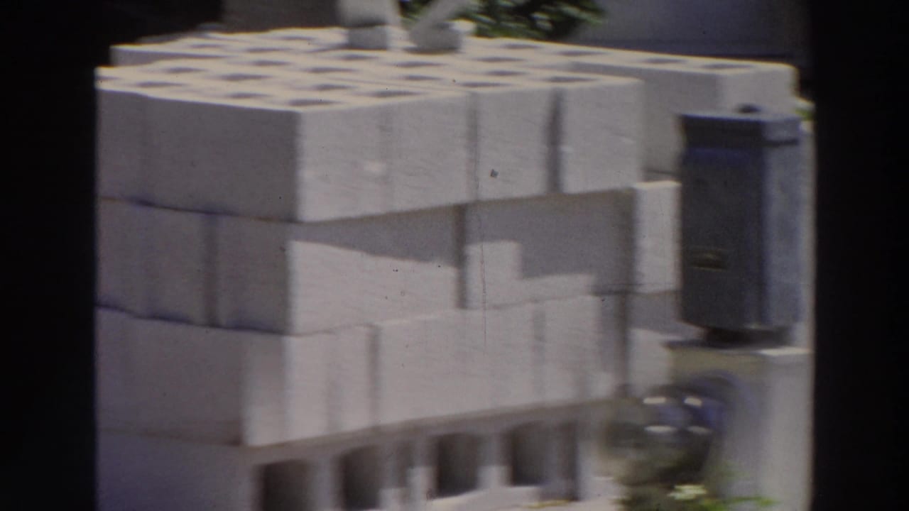 Stacked white cinder blocks beside a roadside area in bright sun.