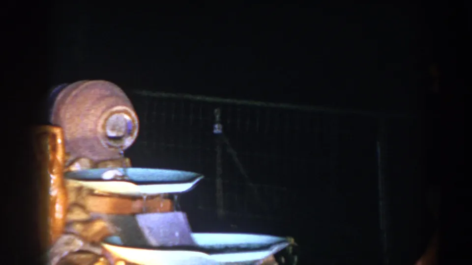 A decorative tiered fountain is framed in the dark backyard, with a chain-link fence behind it.