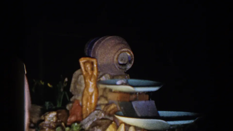 1960 Brighton, Michigan 8mm frame focused on the artificial fountain, with a partial adult figure visible along the edge.