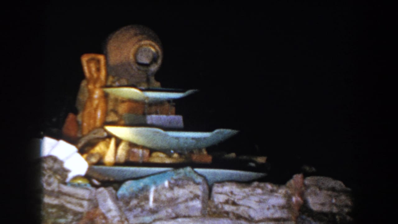 Close view of the illuminated tiered fountain with blue basins and stone base.