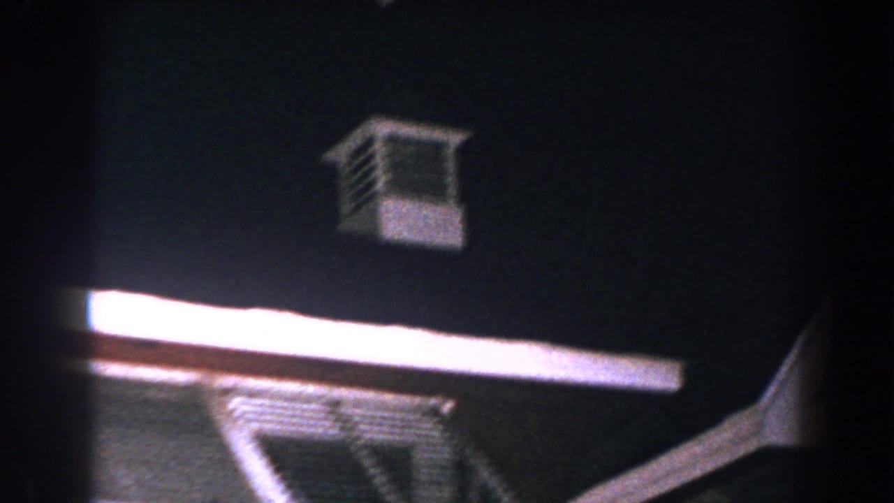 Dark roofline with white trim and a small louvered tower against the night sky.