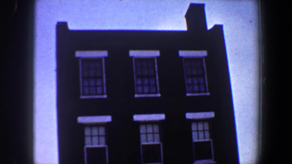 1964 Saint Louis frame showing the upper facade of the building, including dark brick, white-trimmed windows, and a small roof projection.