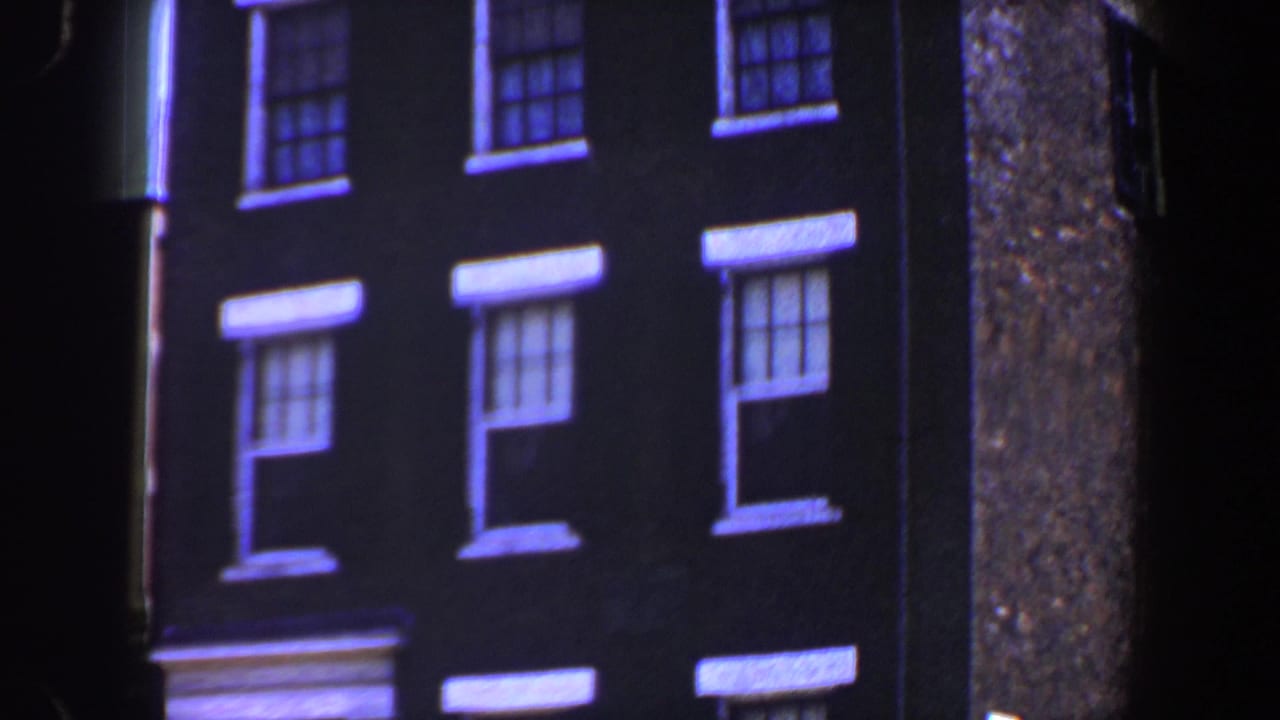 Dark brick building facade with white-trimmed double-hung windows.
