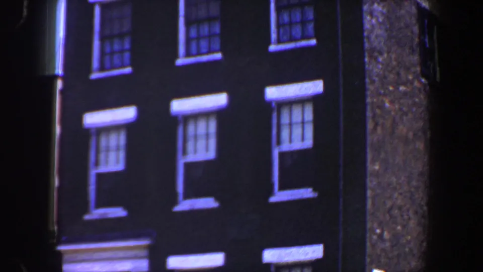 1964 Saint Louis 8mm frame showing an older dark brick facade with rows of white-trimmed double-hung windows.