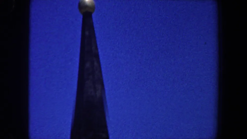 Close view of a pointed church steeple topped by a gold-colored orb in 1964 Saint Louis footage.