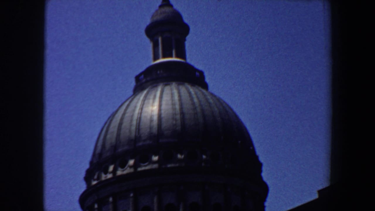Domed building roof with lantern, framed by dark film borders.