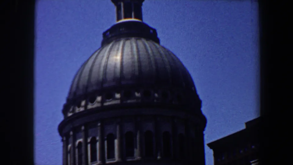 The frame shows more of the dome drum, arched openings, and a neighboring building edge in 1964 Saint Louis footage.