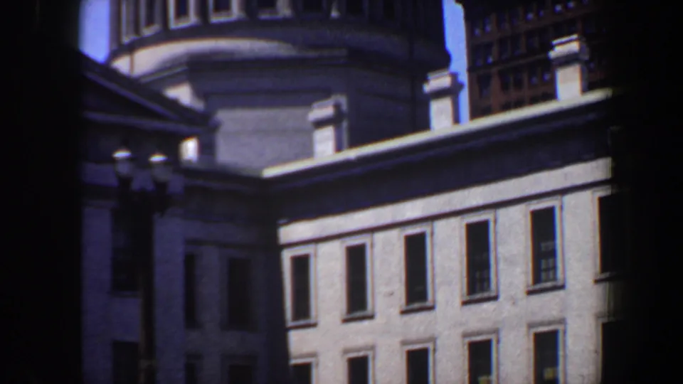 The final frame holds on the domed Saint Louis structure, showing its lower rectangular windows, arched upper windows, and nearby building edge.