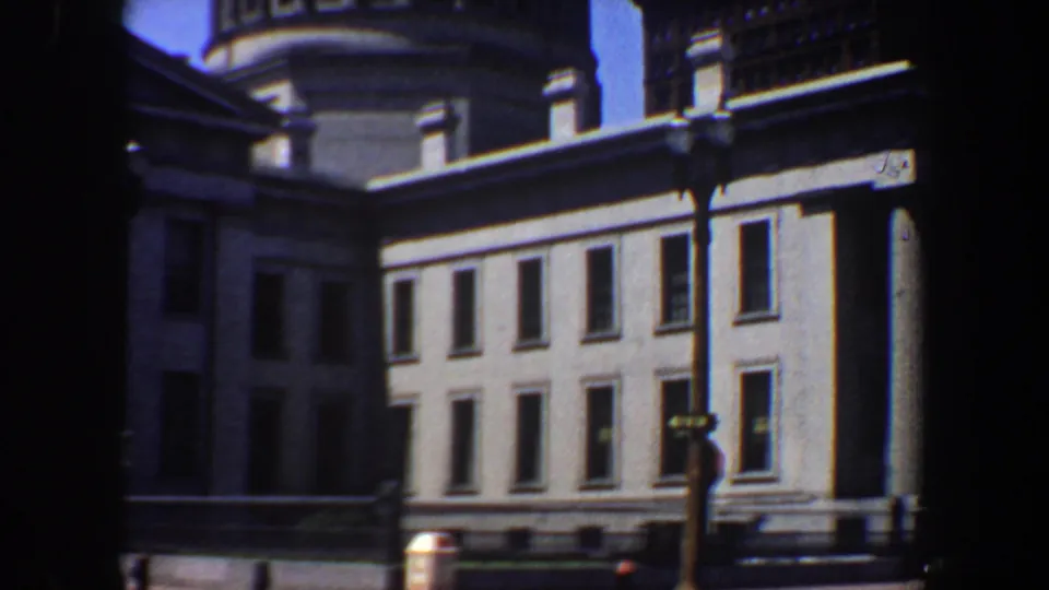 1964 Saint Louis 8mm view of the building from a slightly shifted angle, showing rows of windows, roofline, and street lamp.