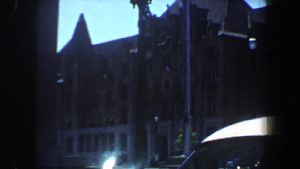 A darker 1964 Saint Louis downtown frame shows tall building silhouettes, a street lamp, and a bright awning or roof edge.