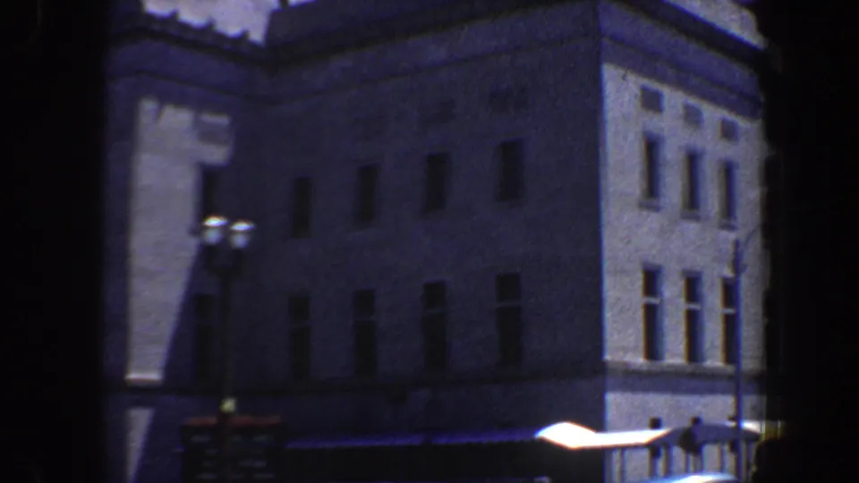 1964 Saint Louis view of a large masonry building corner with rows of windows, a streetlamp, signboard, and bright curbside awning.
