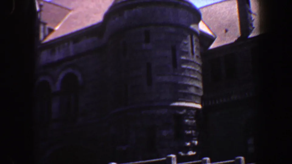 A conical turret and adjoining Gothic Revival stonework fill the frame in this 1964 Saint Louis home-movie view.