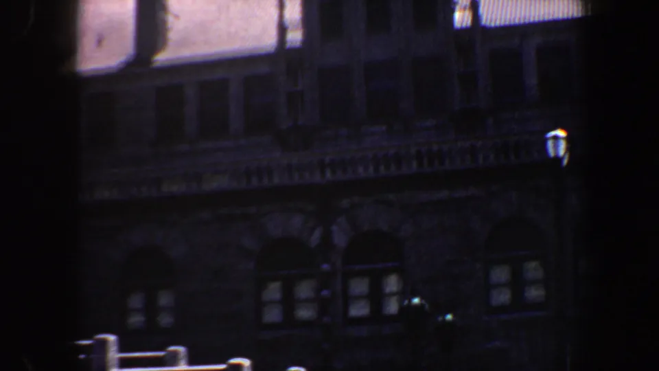 1964 Saint Louis home-movie frame showing arched windows and layered stonework on a large historic-looking facade.