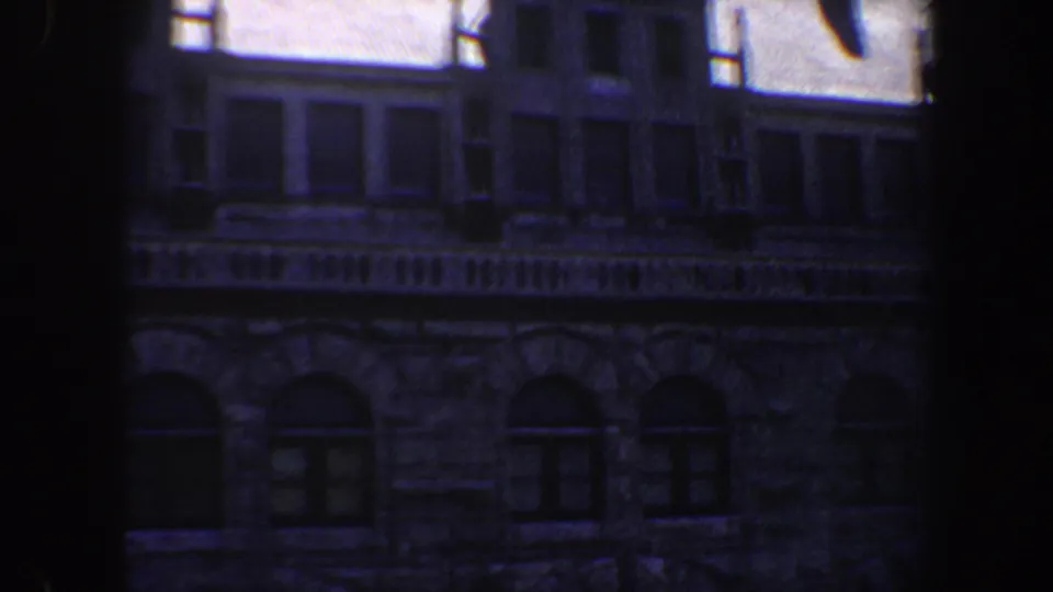 Saint Louis home-movie still from 1964 with a historic stone facade and dark window-like foreground framing.