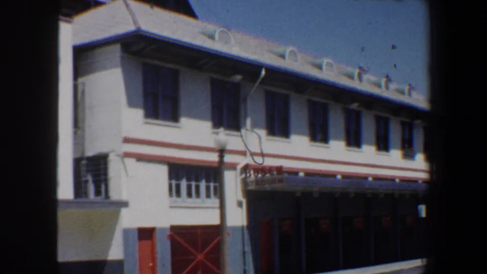 1964 Saint Louis stadium exterior showing the entrance side, red doors, white walls, window rows, and a streetlamp.