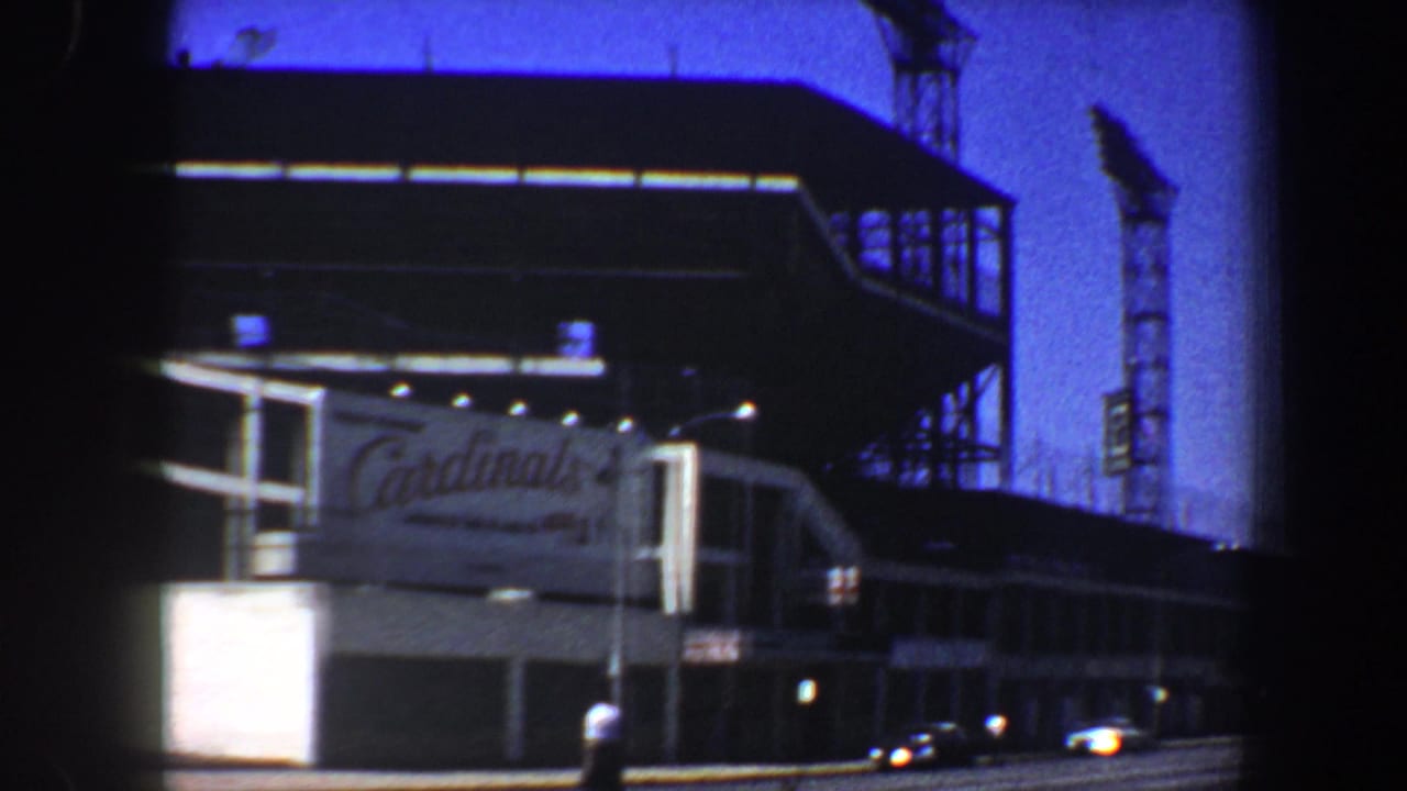 Cardinals sign on a large building with cars and a street visible below.