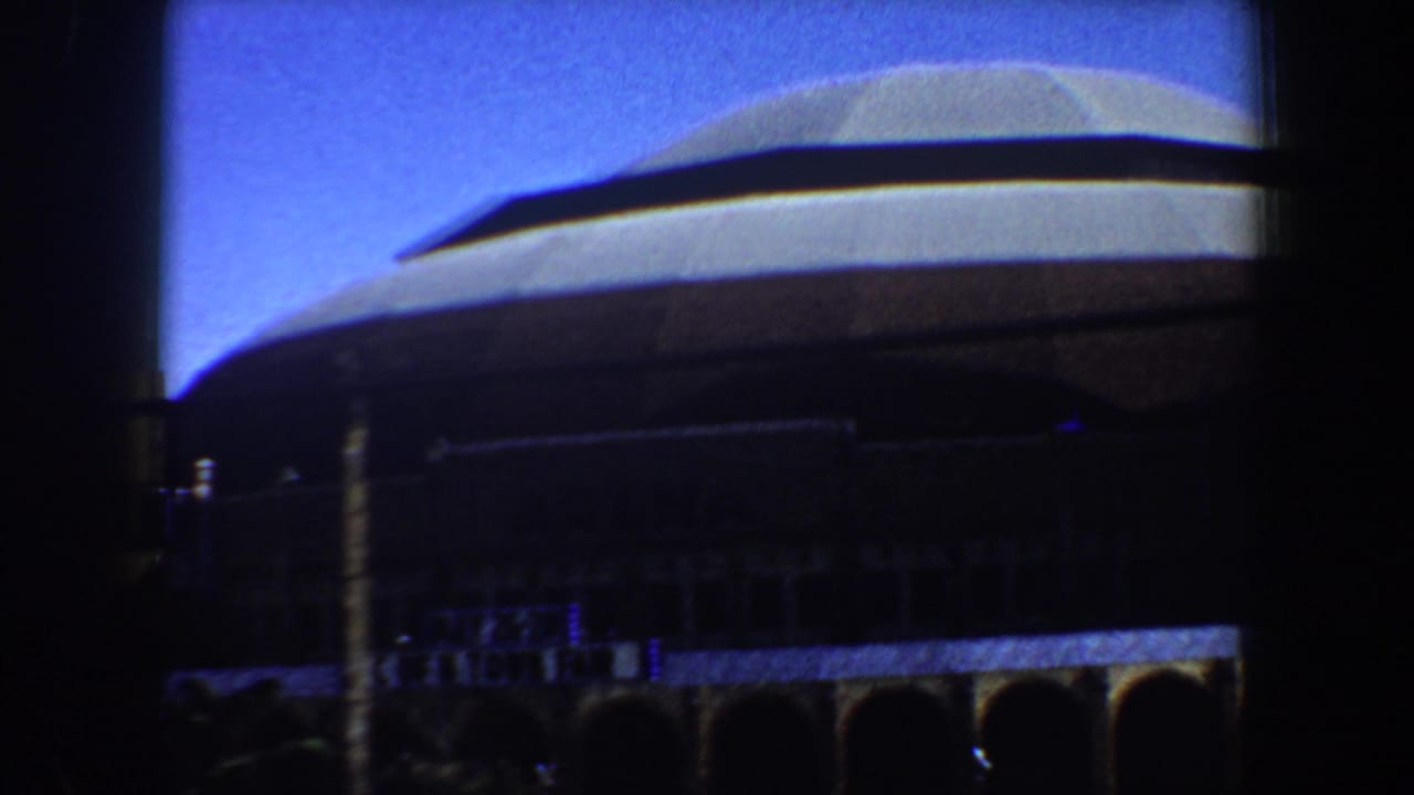 Large domed building seen through dark vehicle-window bars.
