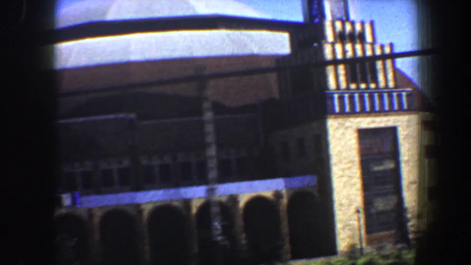 1964 Saint Louis frame of a domed building exterior, with arched openings below and a vertical masonry section at the right edge.