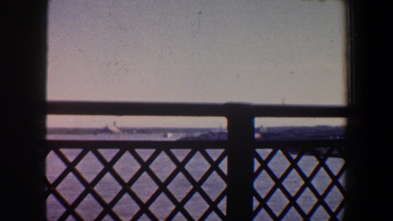 Saint Louis river scene from a bridge, with silhouetted railing, a central support, water, and distant shoreline visible through the frame.
