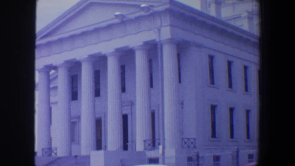 Closer 1964 view of the Saint Louis classical facade, showing columns, pediment lines, windows, and a bit of street furniture.