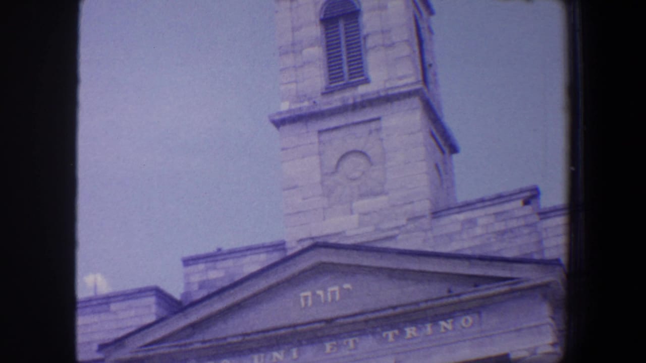 Church tower and pediment with Hebrew letters and partial Latin inscription.
