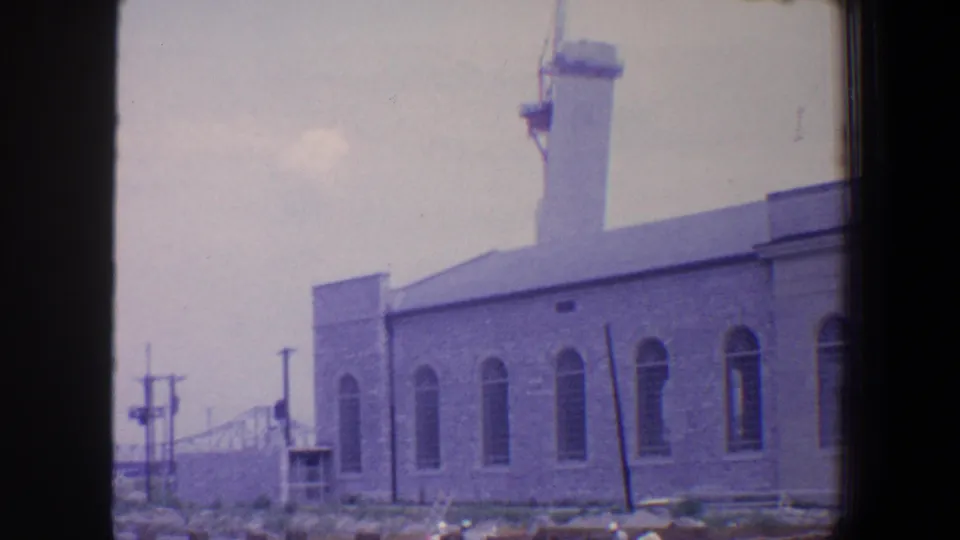 Saint Louis 1964 8mm view of a masonry industrial building, its tower and arched windows framed from across open ground.