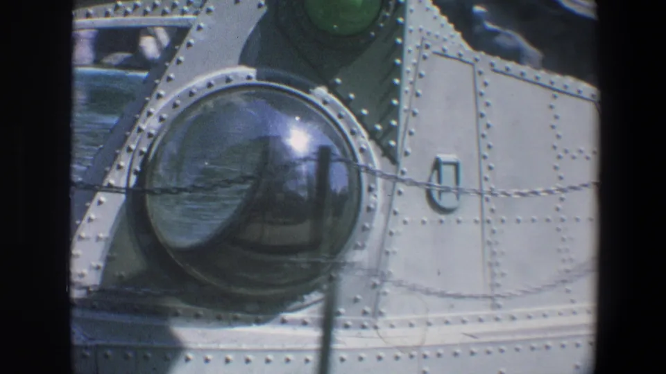 1973 Walt Disney World home-movie frame showing a riveted metallic attraction detail with a round glass window or lens.