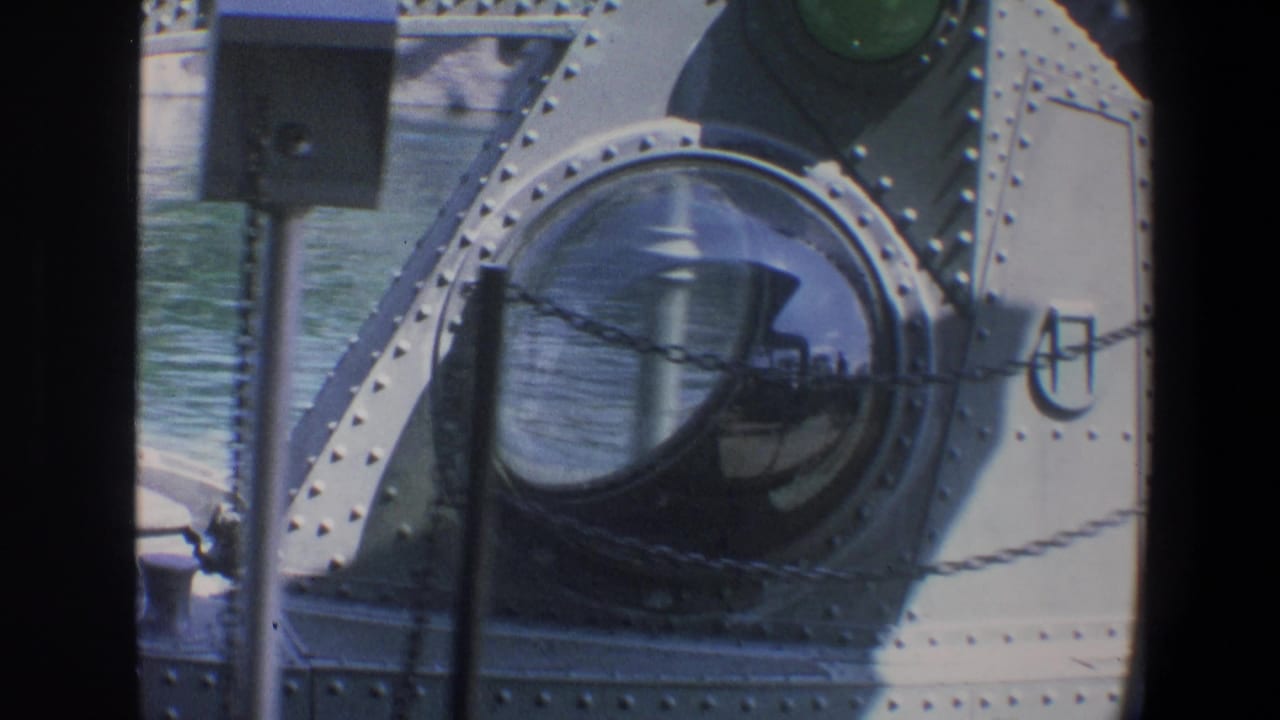 1973 Walt Disney World home-movie frame showing a riveted submarine ride hull, domed portholes, water, and deck hardware.