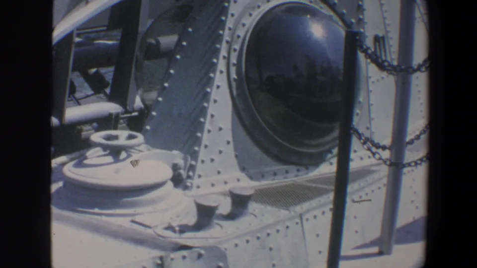 Close 1973 Walt Disney World view of the submarine ride deck with a dark domed porthole, white wheel, chains, and riveted metalwork.