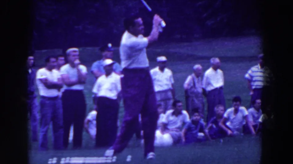 1961 Ridgefield, New Jersey home-movie frame showing the golfer mid-swing with casually dressed spectators close behind.