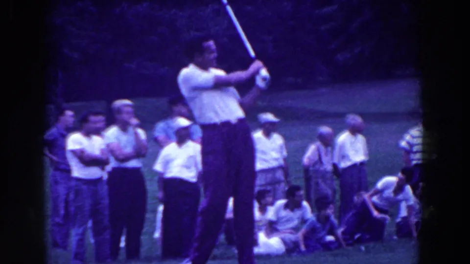 1961 Ridgefield, New Jersey frame showing the golfer's follow-through, with onlookers grouped along the grassy course.