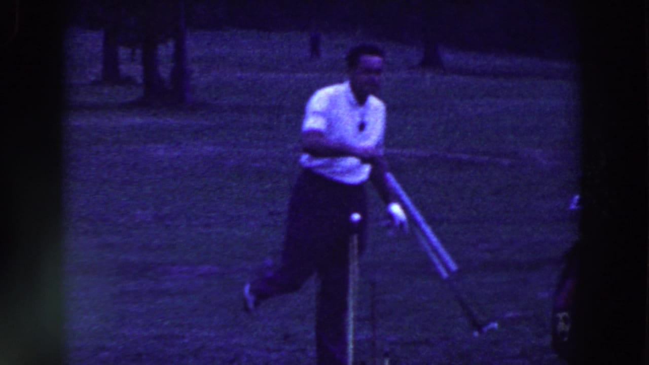 A male golfer in a white shirt swings on a grassy Ridgefield course, with a golf bag and trees visible in the 1961 home-movie frame.