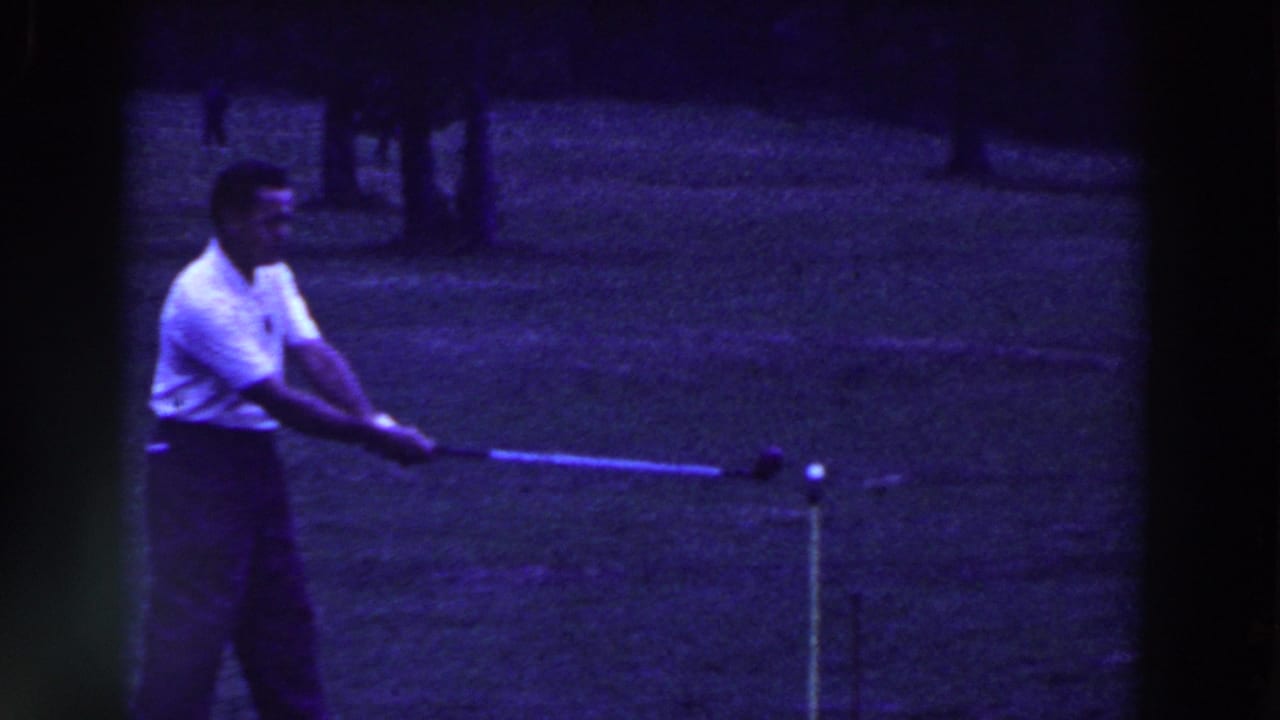 The golfer begins his swing in the 1961 Ridgefield, New Jersey 8mm footage, with the ball and tee marker visible ahead of him.