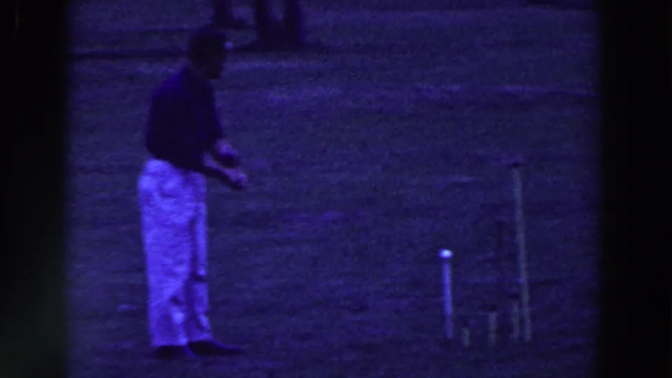 In 1961 Ridgefield, New Jersey, a man in light pants stands with a croquet mallet near a white ball on grass.
