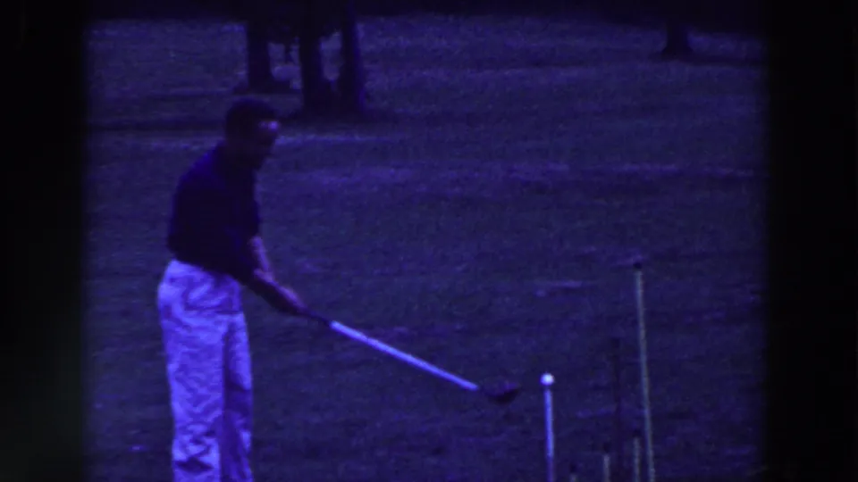 A man in light trousers bends into his croquet stance on a grassy Ridgefield lawn in the 1961 home-movie footage.