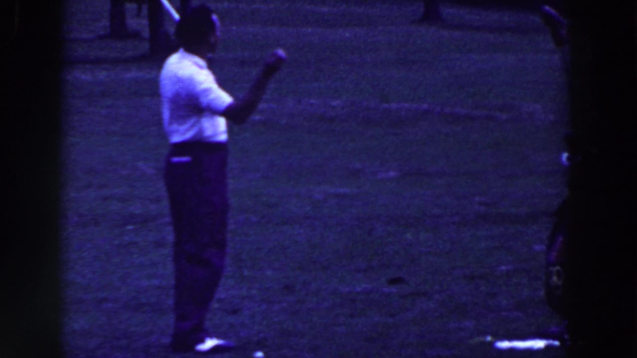In 1961 Ridgefield, New Jersey, a man in a white shirt stands on a grassy golf course with a club in hand.