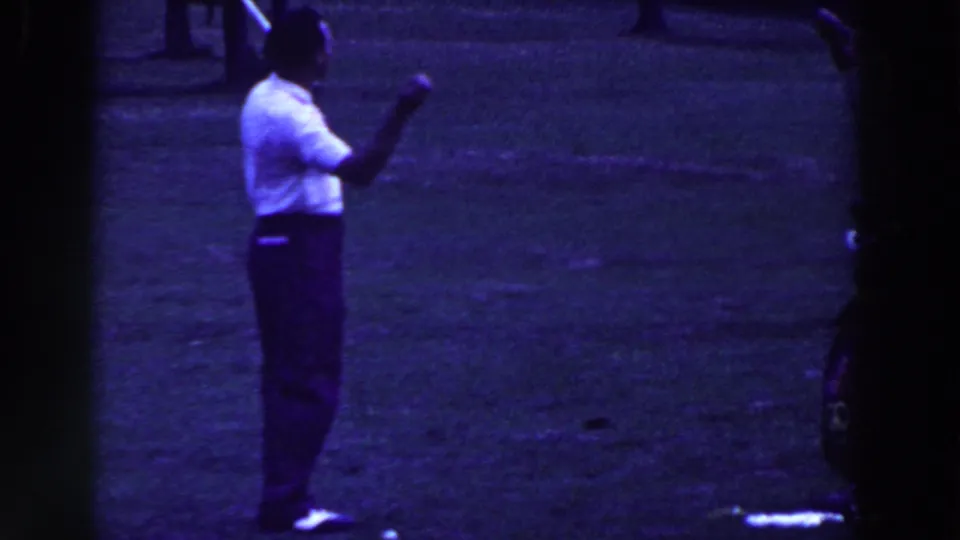 In 1961 Ridgefield, New Jersey, a man in a white shirt stands on a grassy golf course with a club in hand.