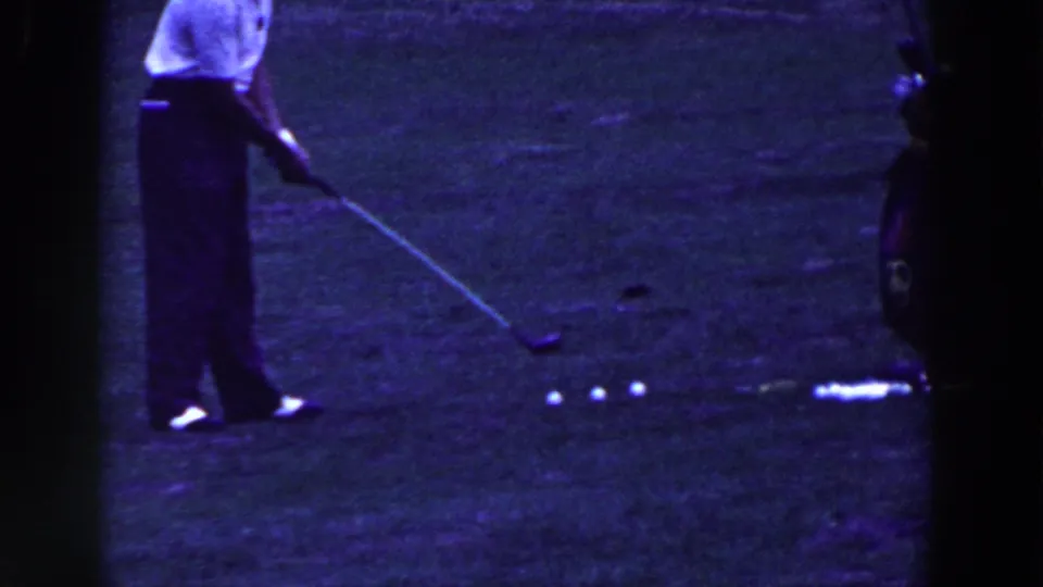 In metadata-supported 1961 Ridgefield, New Jersey footage, a man in a white shirt stands over golf balls on grass.