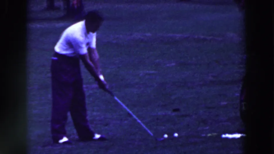 In 1961 Ridgefield, New Jersey footage, a man in a white shirt addresses a golf ball on a grassy course.