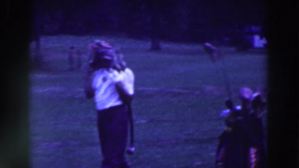 A golfer in 1961 Ridgefield stands with his club while a golf bag or caddy bag rests nearby on the grass.