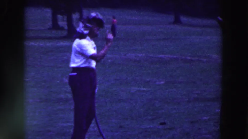 The woman stands in profile on the 1961 Ridgefield golf course, holding the club up while preparing her swing.