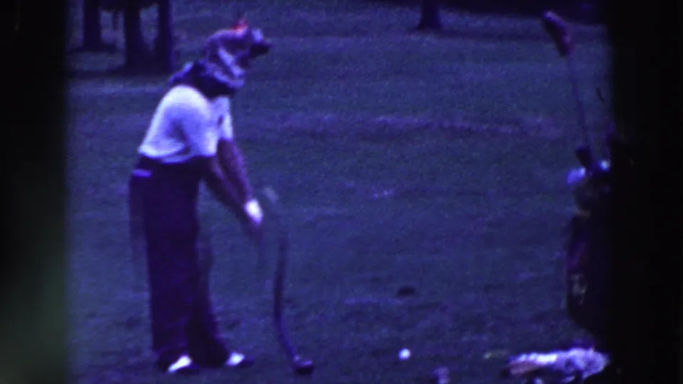 The golfer bends over the ball on the Ridgefield course, using a sharply curved or broken putter.