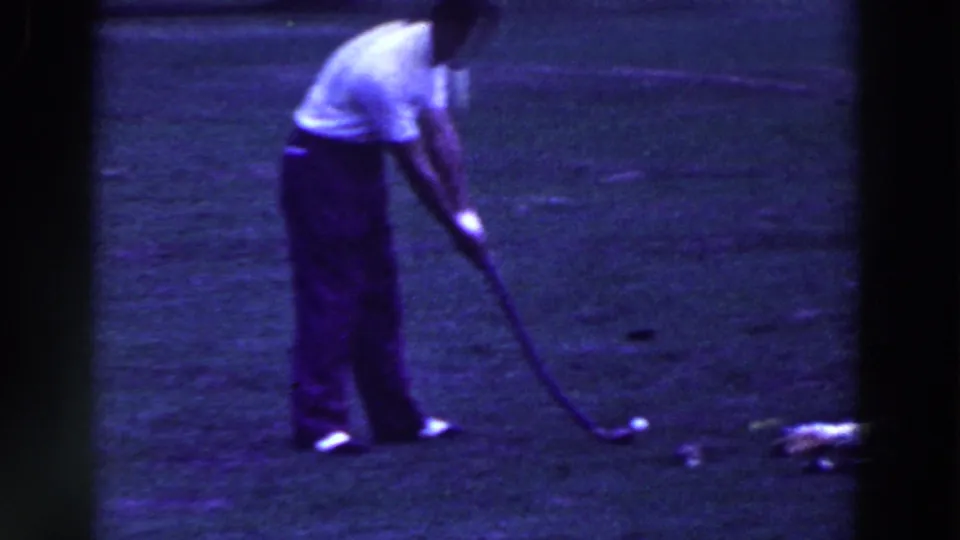 A man addresses a golf ball with his club on a grassy Ridgefield course, seen in soft 1961 8mm home-movie color.