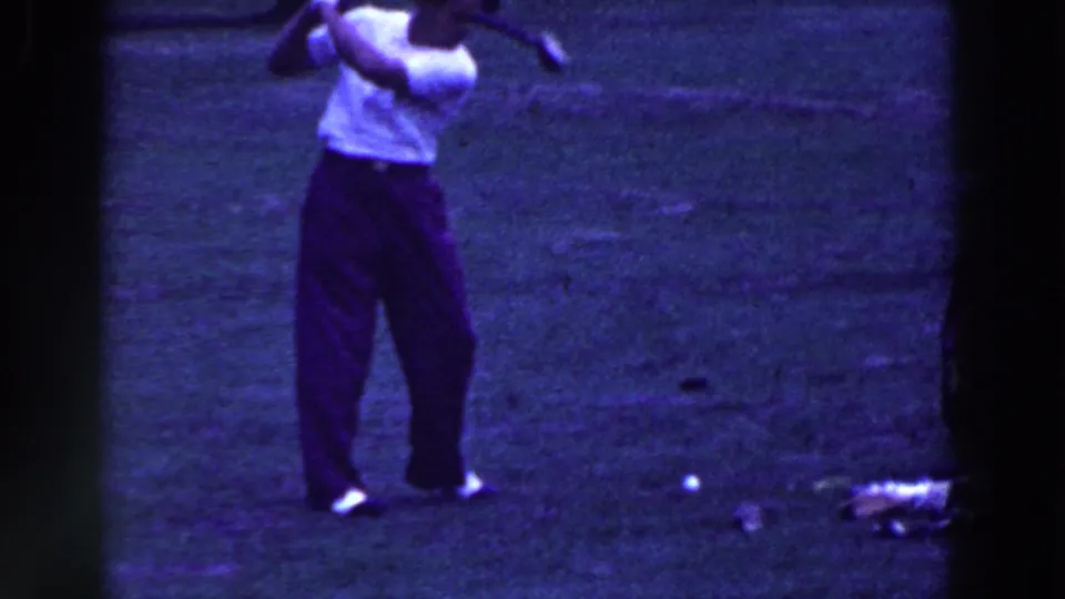 The golfer follows through after a swing, with the ball visible low on the grass in Ridgefield, New Jersey home-movie footage from 1961.
