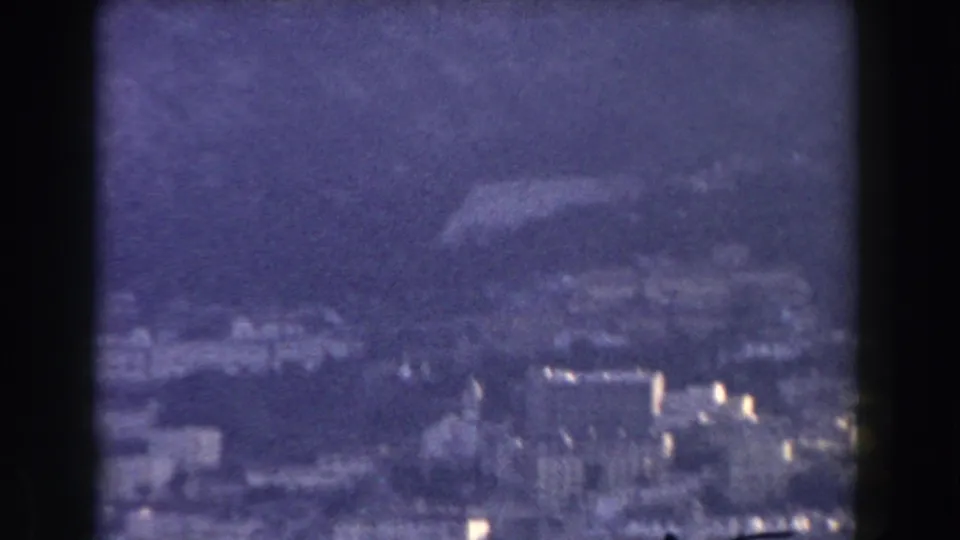 Late frame of the 1959 Gibraltar view, with pale buildings and hillside detail softened by haze and film grain.