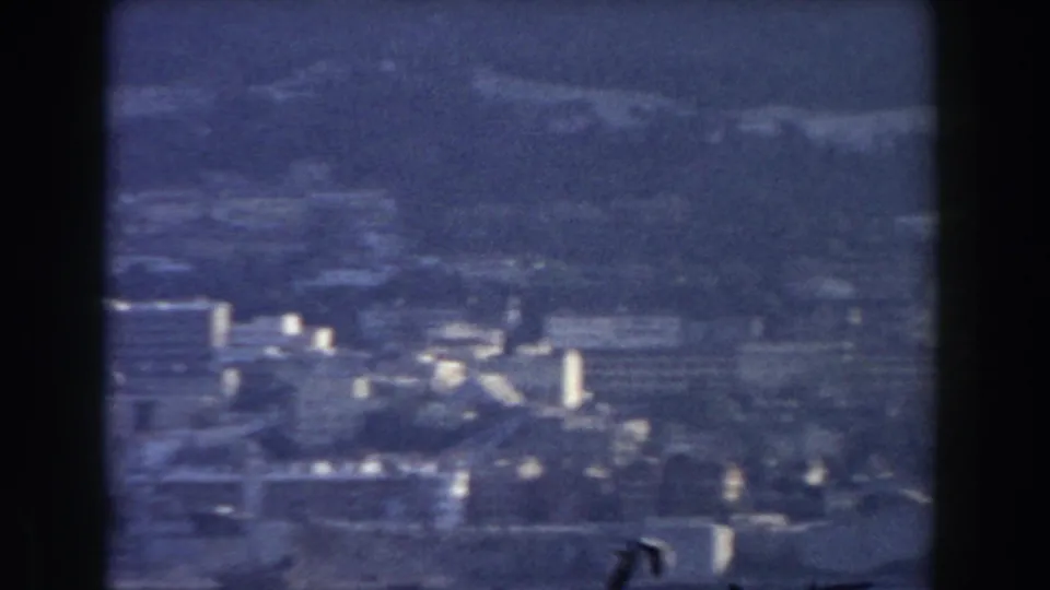1959 Gibraltar panorama with scattered white buildings, hillside roads or terraces, and the mountain rising behind the city.