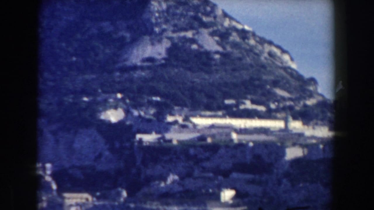 Closer view of Gibraltar hillside with buildings below the rocky slope.