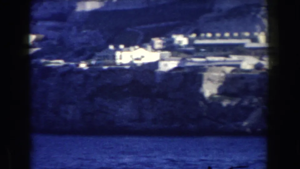 Gibraltar waterfront and hillside structures appear beneath the Rock in this 1959 8mm travel-film frame.