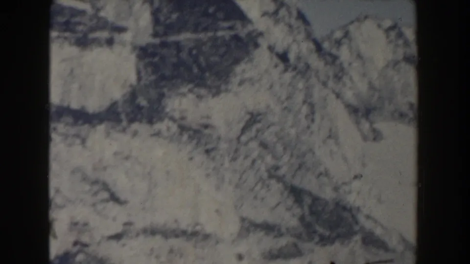 1959 Gibraltar 8mm frame showing close rocky terrain, pale stone surfaces, and dark creases across the slope.